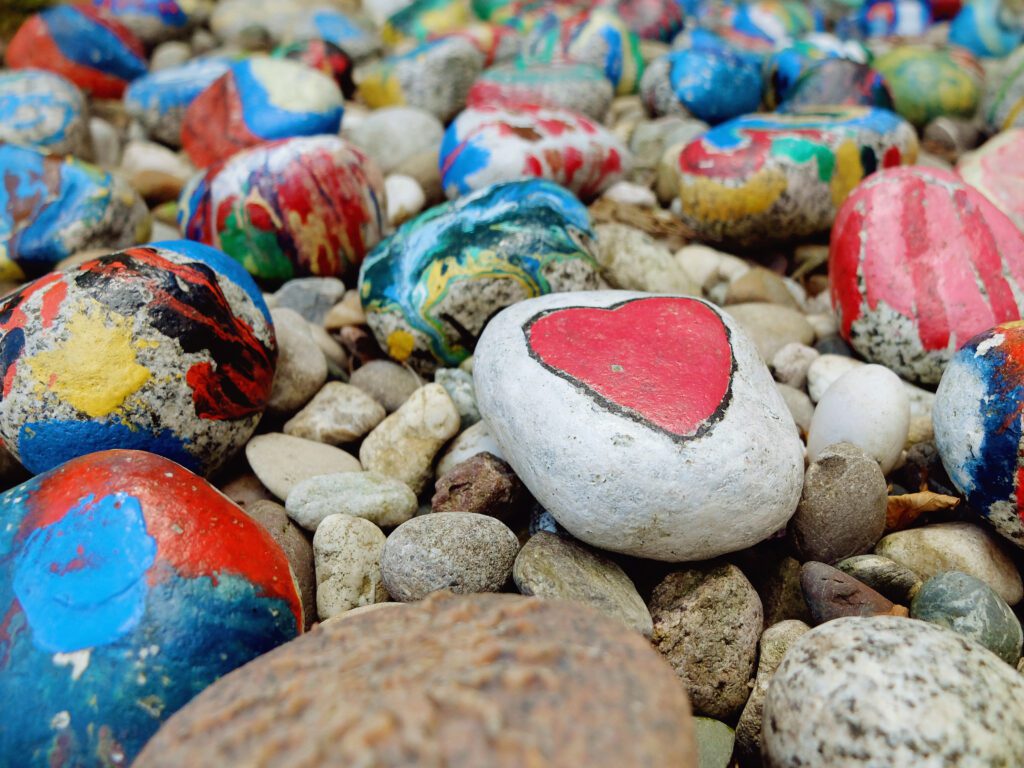 Painted rock with a heart on display in a garden